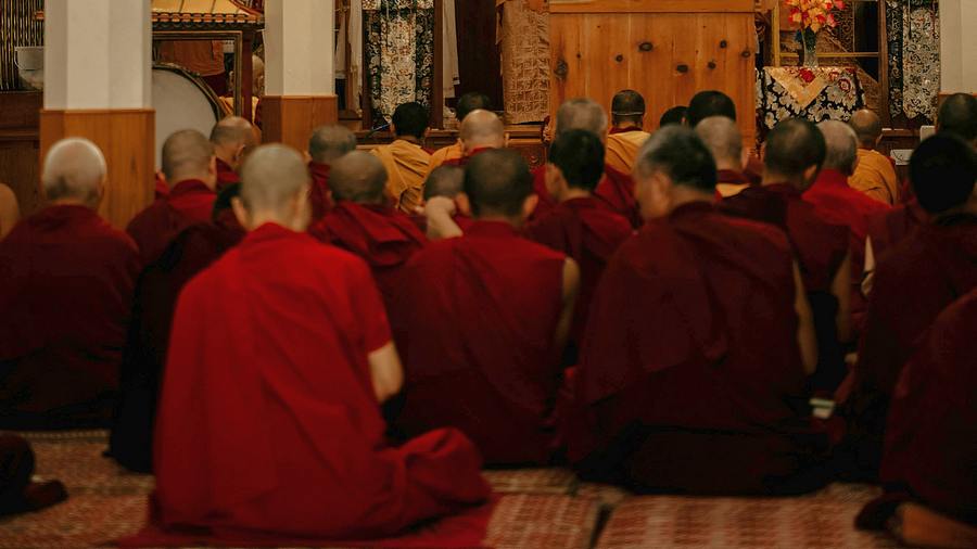 Monastics sitting at a shrine.